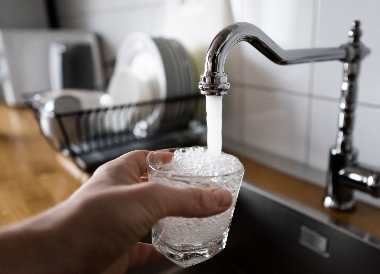 Glass filling up with water from faucet