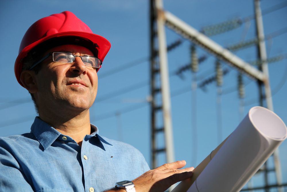 Electrical manager holding blueprints